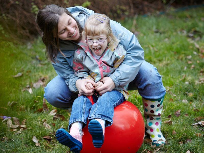 a mother holding her child on a space hopper