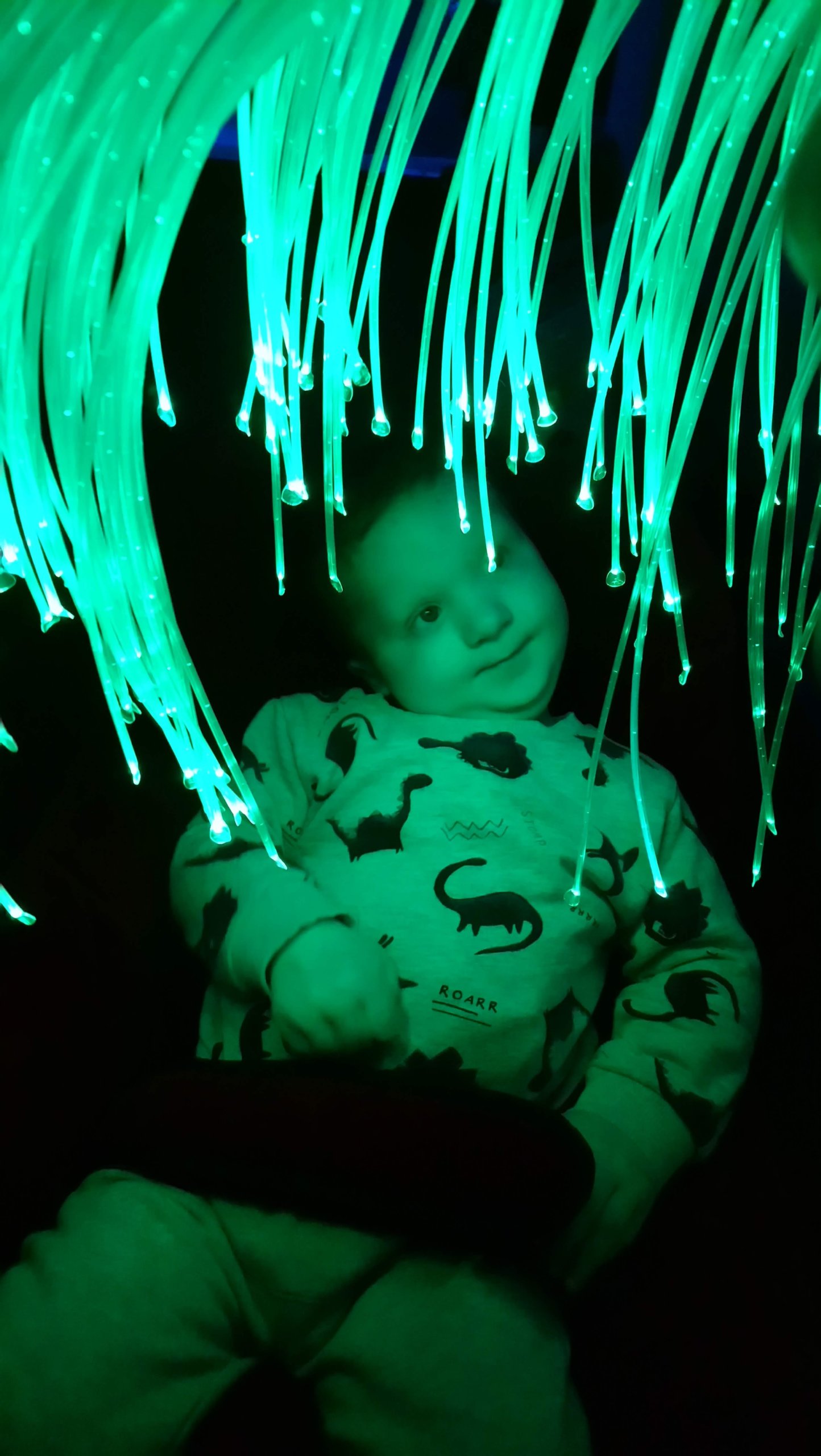 Evan gazing at green fibre optic lights