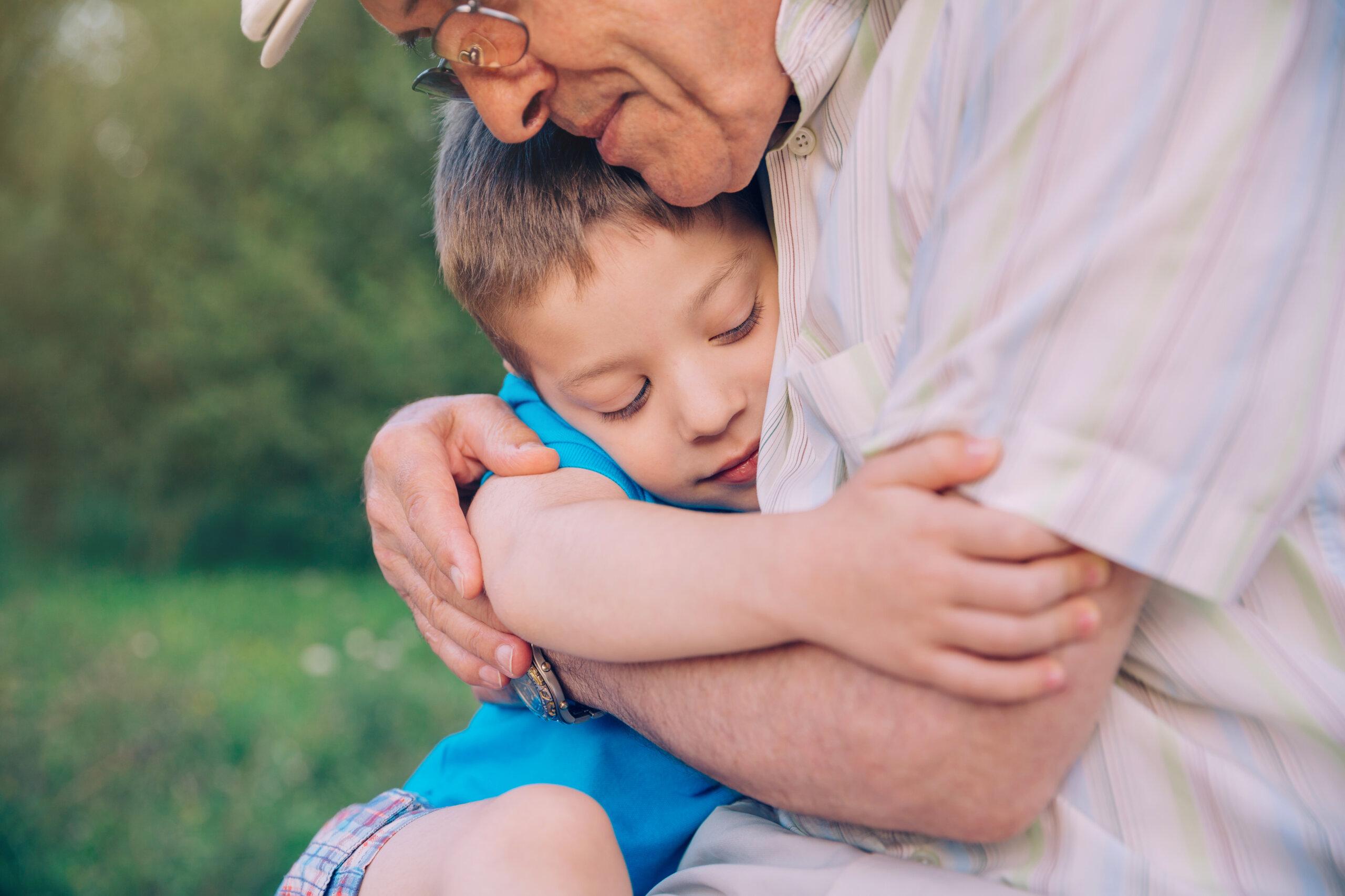 Portrait,Of,Happy,Grandson,Hugging,Grandfather,Over,A,Nature,Outdoor