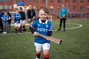 Child in Rangers kit holding the Relay baton