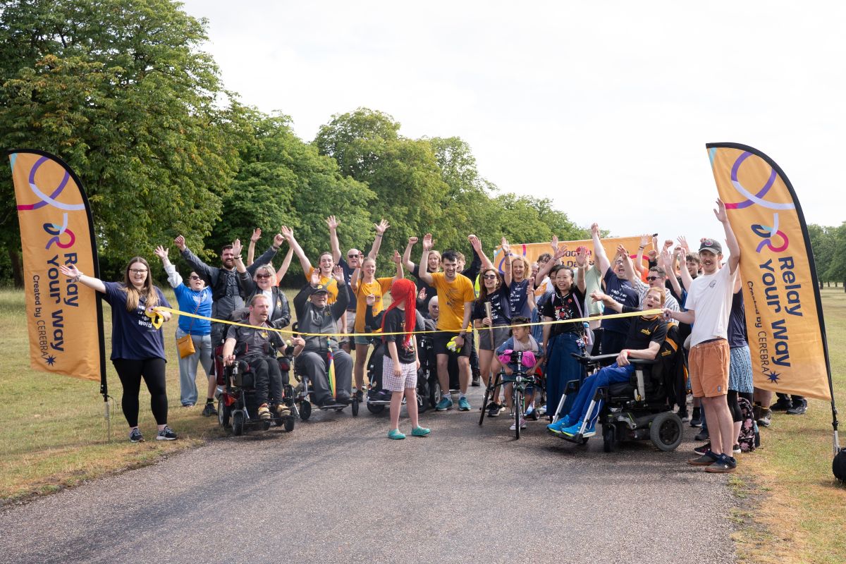 Group of people, some using wheelchairs and frame-runners, gathered on the long walk at Windsor before starting the final 200m of the relay