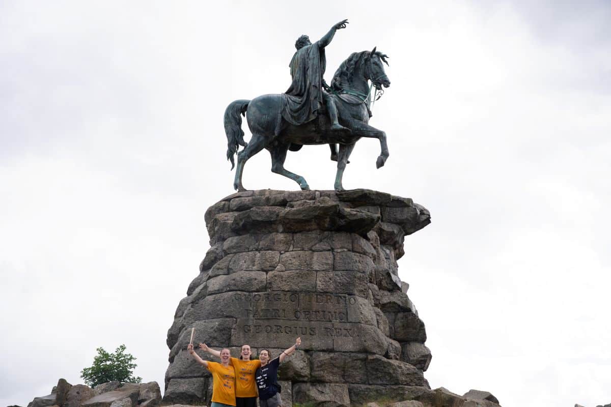 The relay team and baton at The Copper Horse statue of King George III in Windsor