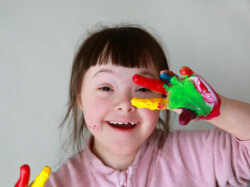 Little girl with paint on her hands.