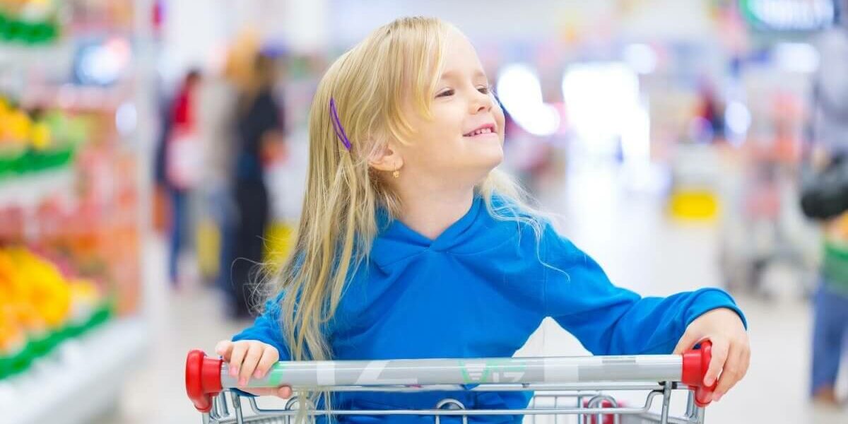 little girl in shopping trolley give as you shop