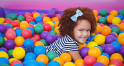smiling little girl in a ball pool