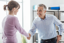 Man shaking woman's hand